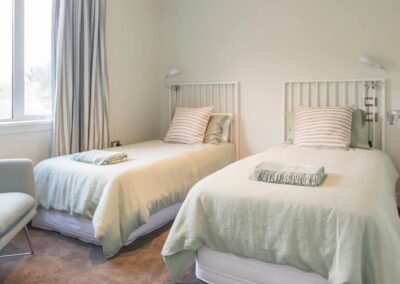 A bedroom with two single beds in an Olive Estate house