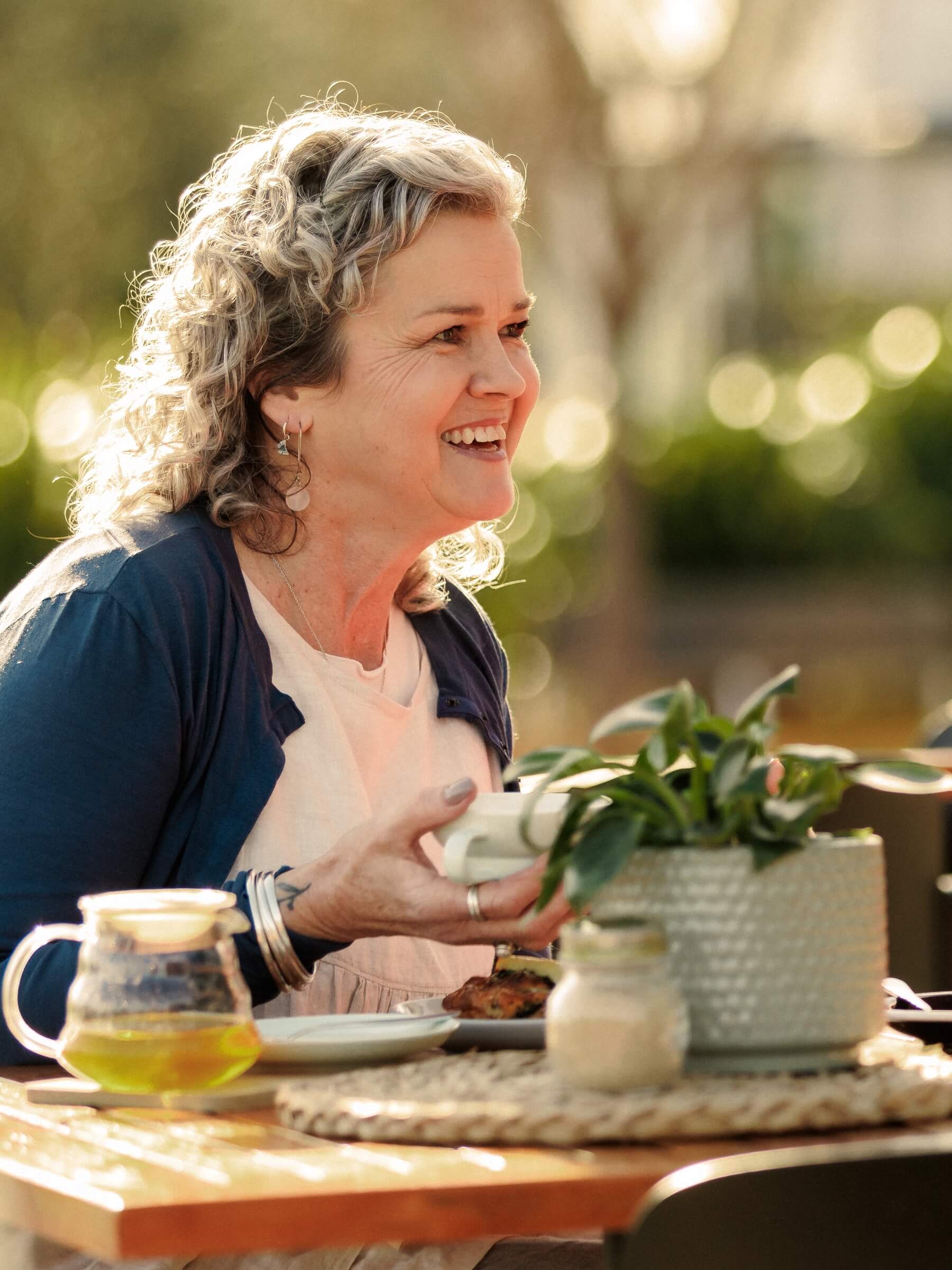 Resident enjoying tea and dining outdoors at Paragon Eatery in Olive Estate Lifestyle Village.